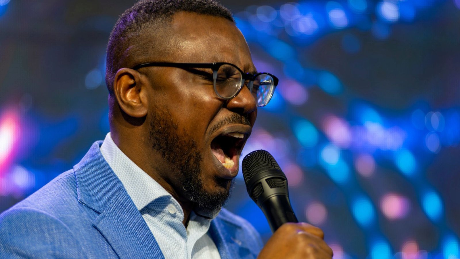 A worship leader singing passionately into a microphone